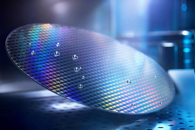 Semiconductor silicon wafer reflecting circuit patterns under cleanroom lights, representing advanced HBM and enterprise DRAM memory chip fabrication for AI data centers.